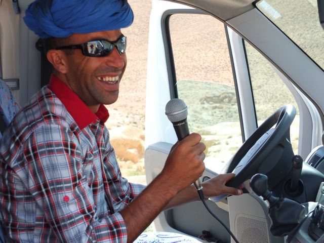 Smiling driver holding microphone in van