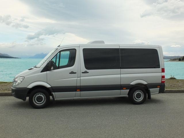 Silver van parked by blue lake